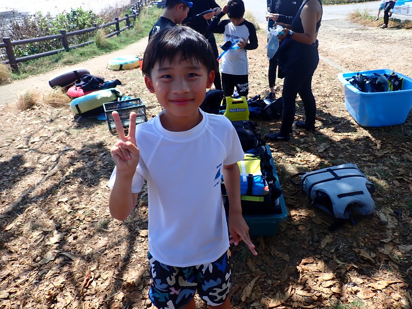 過去のツアーで撮影した器材を準備するグループの中でピースをする男の子