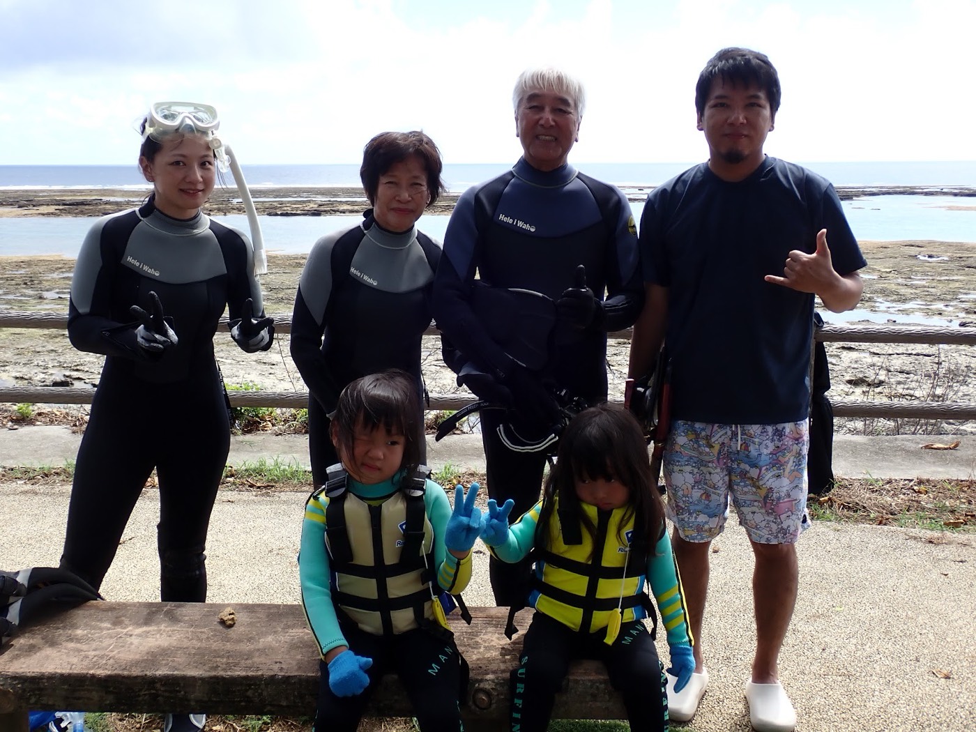 天然水族感で紹介する、天然水族館を背景に、ウェットスーツ姿で並んで立つ参加者の集合写真