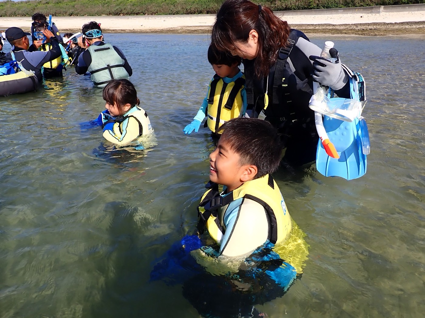 天然水族感。穏やかな浅瀬で、担当の池田が小さなお子様たちに寄り添っている様子